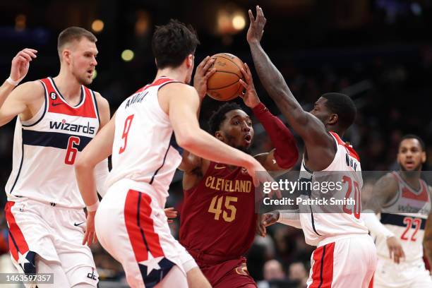Donovan Mitchell of the Cleveland Cavaliers drives between Kristaps Porzingis, Deni Avdija and Kendrick Nunn of the Washington Wizards during the...