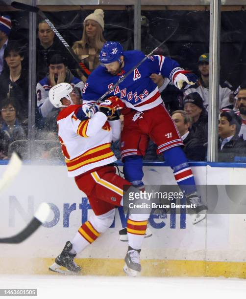 Barclay Goodrow of the New York Rangers is checked by Nikita Zadorov of the Calgary Flames during the first period at Madison Square Garden on...