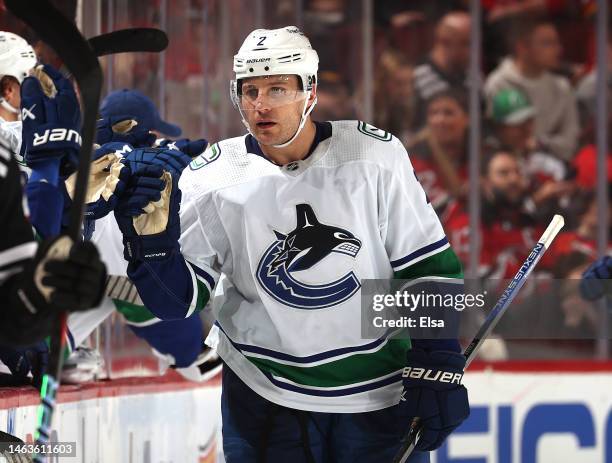 Luke Schenn of the Vancouver Canucks is congratulated by teammates on the bench after he scored in the second period against the New Jersey Devils at...