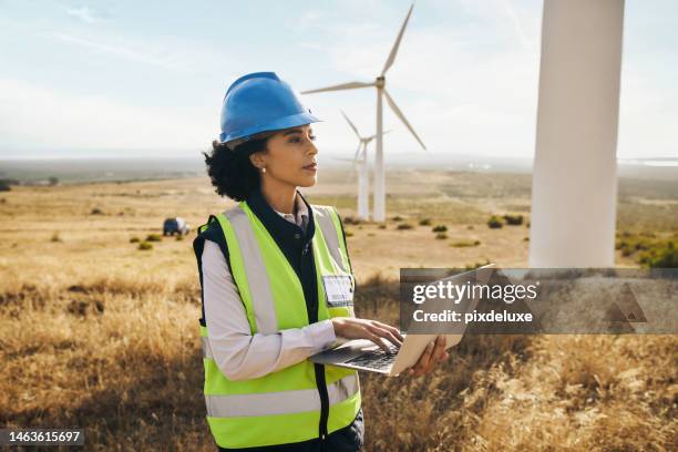 moulin à vent à la ferme, femme noire en énergie propre tapant sur ordinateur portable et production d’électricité avec des éoliennes en afrique. energie renouvelable, femme ingénieur en agriculture, environnement et équipements de sécurité - structure actionnée par le vent photos et images de collection