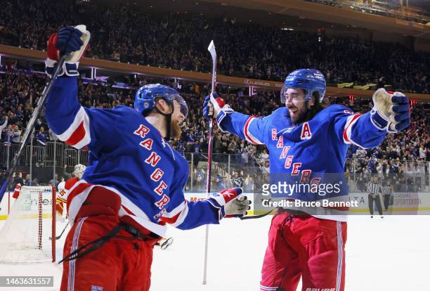 Alexis Lafreniere of the New York Rangers celebrates his game-winning overtime goal against the Calgary Flames and is joined by Mika Zibanejad at...