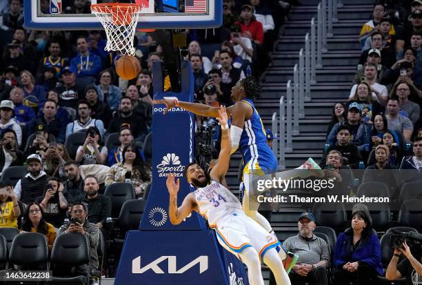 Jonathan Kuminga of the Golden State Warriors passing the ball collides with Kenrich Williams of the Oklahoma City Thunder during the fourth quarter...