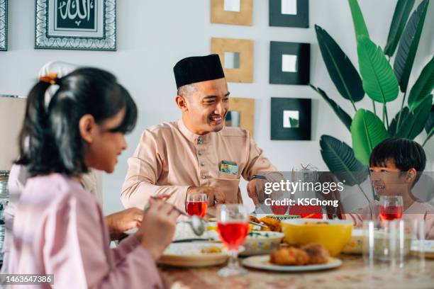 asiatische malaiische familie beim essen während hari raya aidilfitri - hari raya celebration stock-fotos und bilder