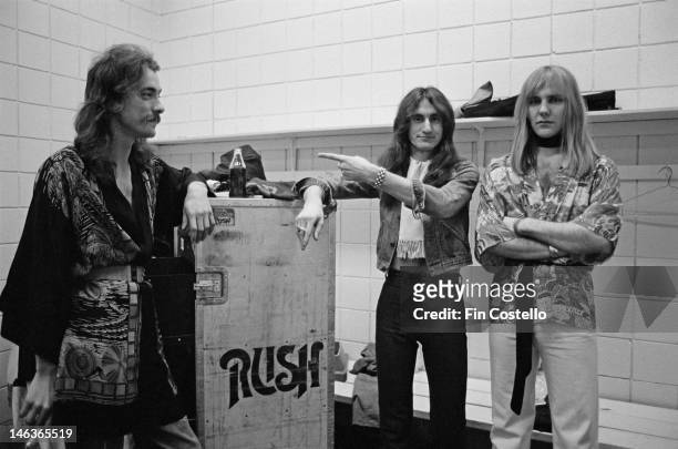 1st DECEMBER: Neil Peart, Geddy Lee and Alex Lifeson from Canadian group Rush pose next to a flight case backstage in Springfield, Massachusetts, 9th...