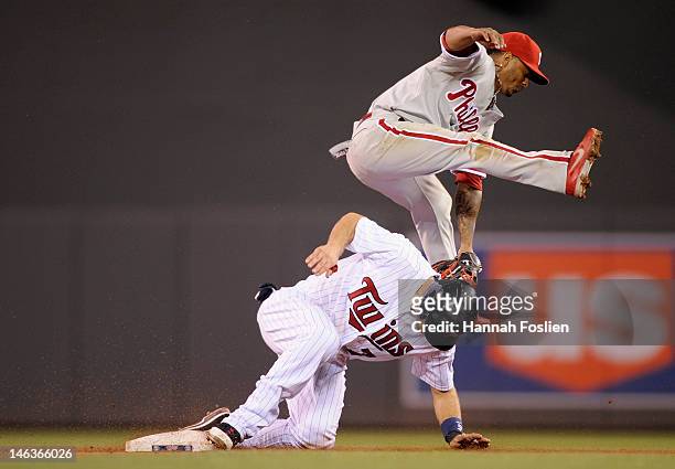 Michael Martinez of the Philadelphia Phillies attempts a play as Joe Mauer of the Minnesota Twins steals second base during the eighth inning on June...