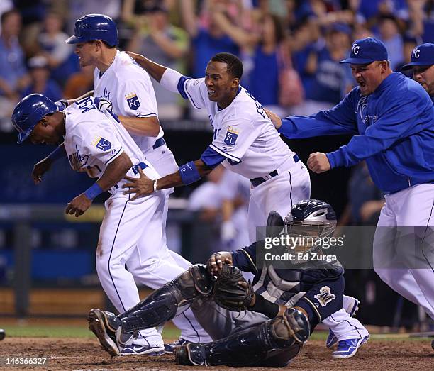 Jarrod Dyson is congratulated by Mitch Maier, Alcides Escobar and Billy Butler after scoring the game-winning run as Martin Maldonado of the...