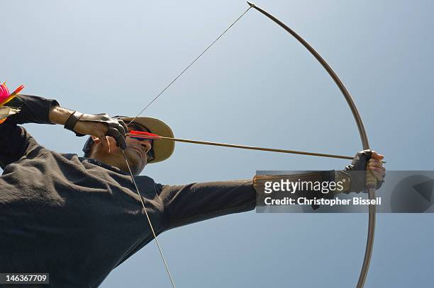 archer drawing longbow - bogenschießen stock-fotos und bilder
