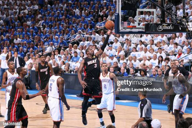 Dwyane Wade of the Miami Heat goes to the basket between Kendrick Perkins, Thabo Sefolosha and Serge Ibaka of the Oklahoma City Thunder during Game...