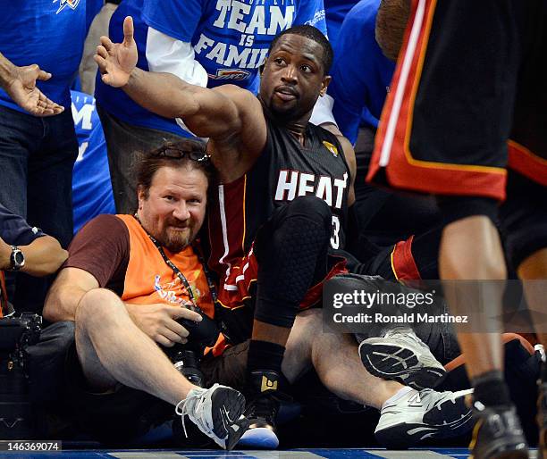 Dwyane Wade of the Miami Heat falls into photographer Lawrence Wayne Smith in the first half against the Oklahoma City Thunder in Game Two of the...