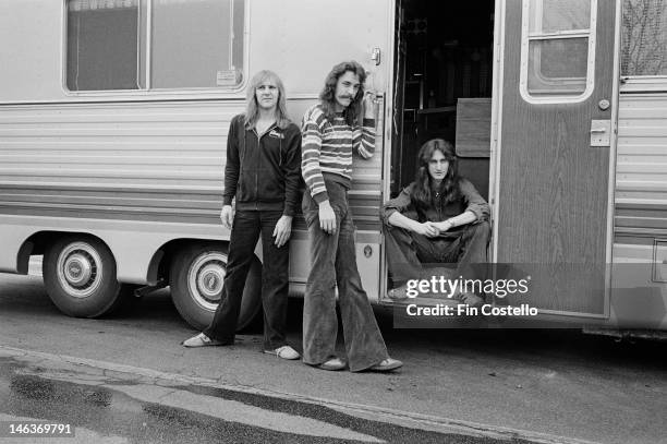 1st MAY: Canadian band Rush posed outside their mobile trailer in Illinois, United States during their All the World's a Stage tour in May 1977. Left...