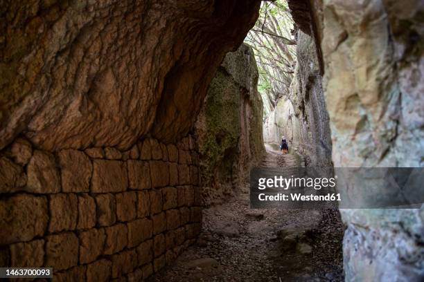 active senior woman walking up stairs amidst rocks - hollow stock pictures, royalty-free photos & images