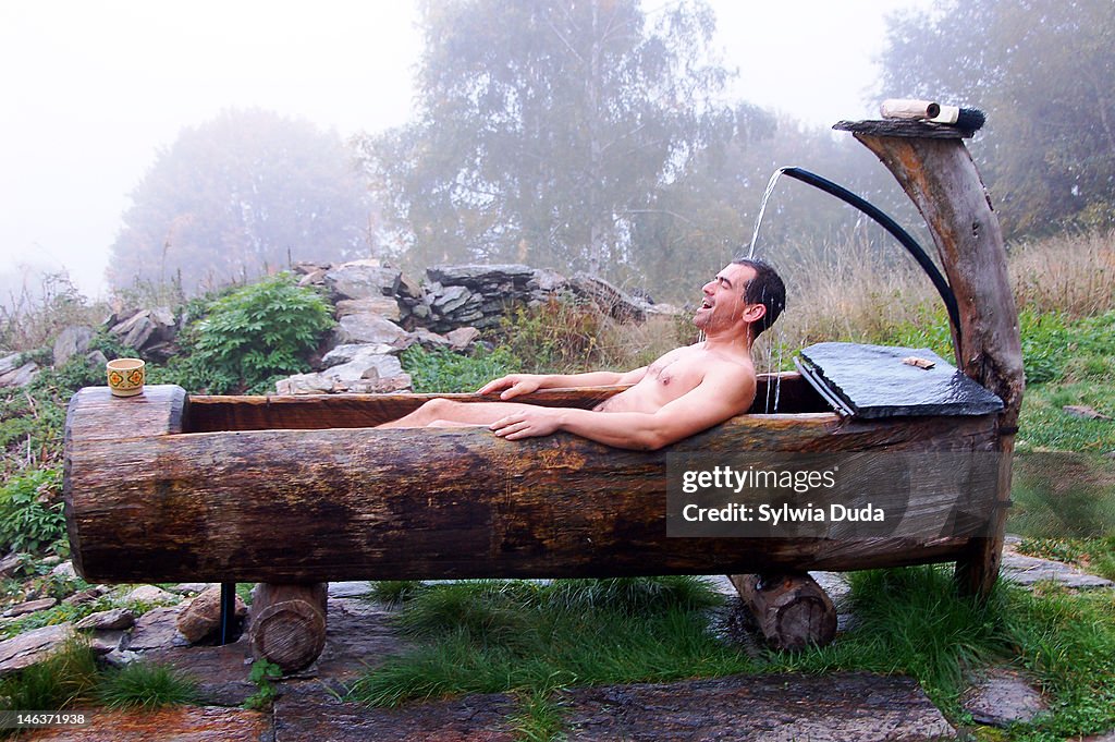 Man in wooden bathtub