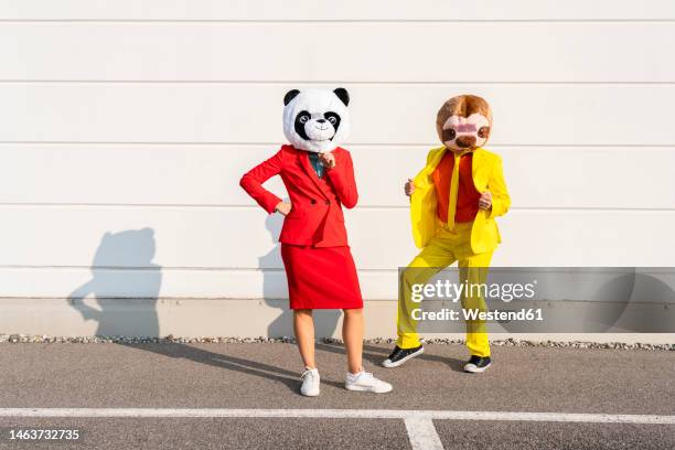man and woman wearing animal masks standing in front of wall - bear suit 個照片及圖片檔