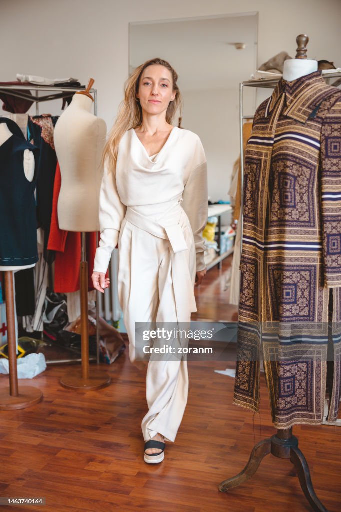 Ihren umgestalteten Jumpsuit im Atelier der Schneiderin anprobieren und in die Kamera schauen