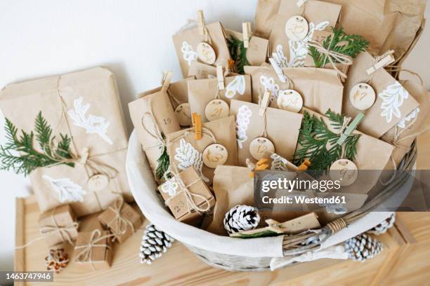 decorated paper bags prepared for advent calendar and kept in basket - advent stock-fotos und bilder