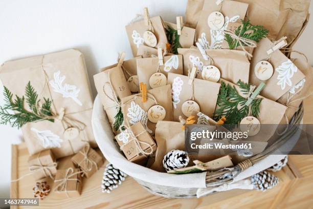 decorated paper bags prepared for advent calendar and kept in basket - advent calendar stock pictures, royalty-free photos & images