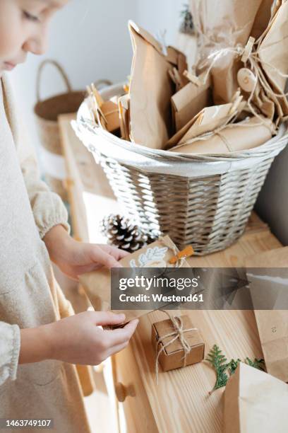 girl looking at gifts from advent calendar at home - child with advent calendar stock pictures, royalty-free photos & images