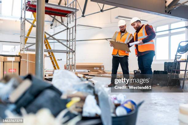 young engineers having discussion over document at construction site - architect on site stock pictures, royalty-free photos & images