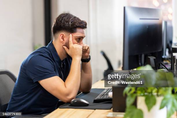 frustrated businessman sitting in front of desktop pc at office - mann vor pc stock-fotos und bilder