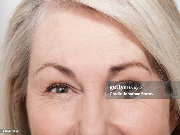 shot of mature womans green eyes - wrinkled stock pictures, royalty-free photos & images