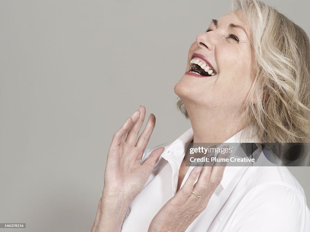 Woman with head back laughing, hands clapping