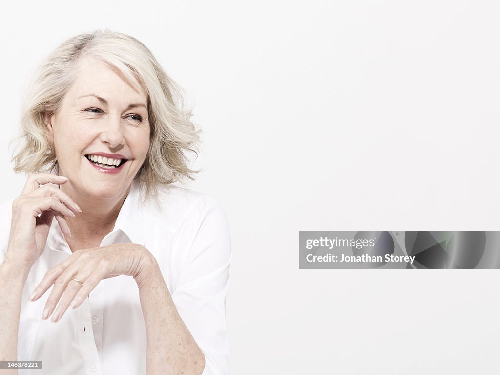 Mature woman sitting wearing in white shirt