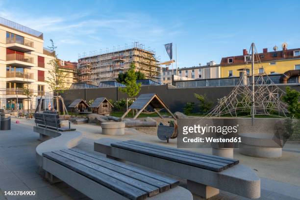 germany, bavaria, munich, empty benches in front of residential playground at dusk - bavarian man in front of house stock-fotos und bilder