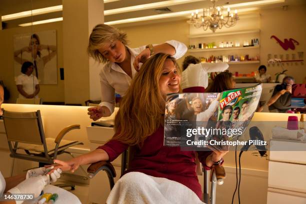 Patricia Lopes de Oliveira a devote football fanatic reads Lance magazine, Brazil's pricipal dedicated football magazine, in a Hair dressing salon in...