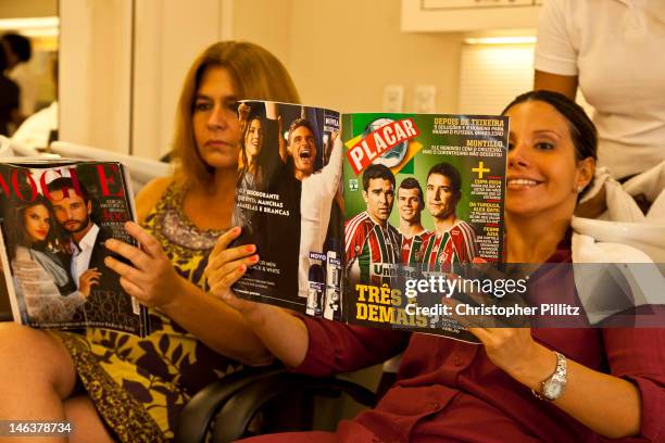 Patricia Lopes de Oliveira a devoted football fanatic reads Lance magazine, Brazil's pricipal dedicated football magazine, in a Hair dressing salon...
