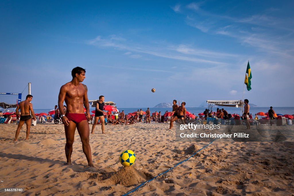 Men play volley-football on beach