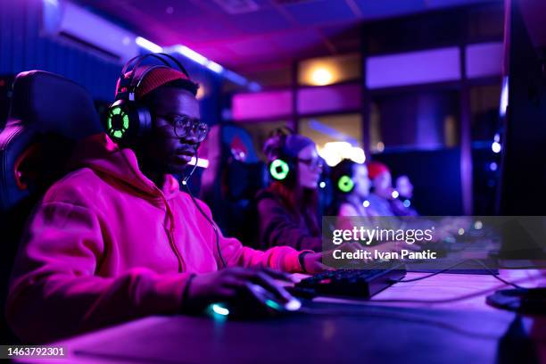 black gamer and his friends playing video games in entertainment club. - esports stock pictures, royalty-free photos & images