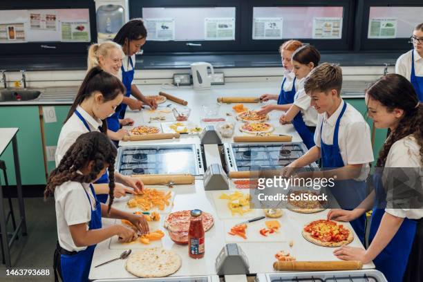 pizza machen im unterricht - children cooking school stock-fotos und bilder