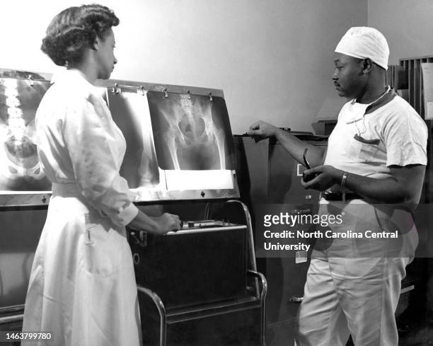 Nurse and doctor examining X-ray in hospital. Similar to hospitals throughout the country, Lincoln Hospital's surgery residents often reviewed x-rays...