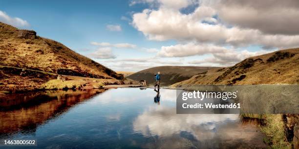 hiker walking by llyn y fan fach, brecon beacons, wales - day in the life stock pictures, royalty-free photos & images