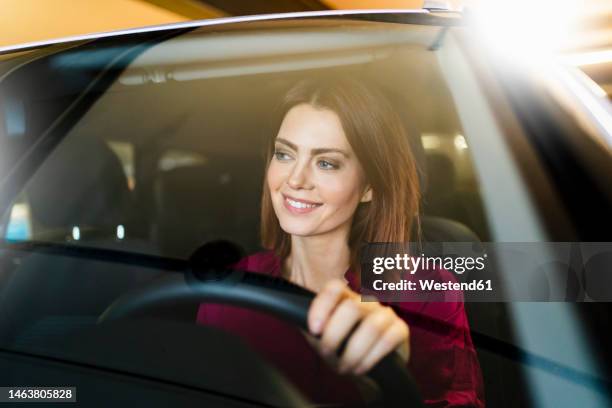 happy businesswoman driving car seen through windshield - steuern stock-fotos und bilder