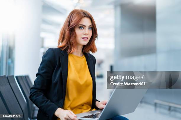 businesswoman with laptop sitting on chair - blazer jacket stockfoto's en -beelden