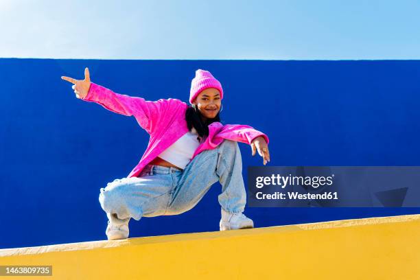 smiling young dancer sitting on wall - breakdancing stock pictures, royalty-free photos & images