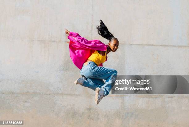 young woman hip hop dancing in front of wall - hip hopper stock pictures, royalty-free photos & images