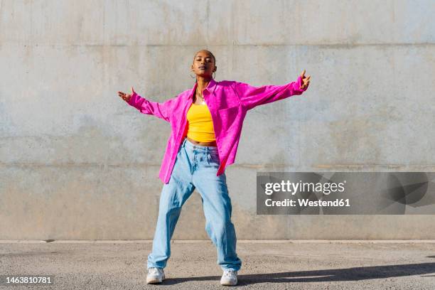 young dancer with arms outstretched in front of wall - arms open stock pictures, royalty-free photos & images