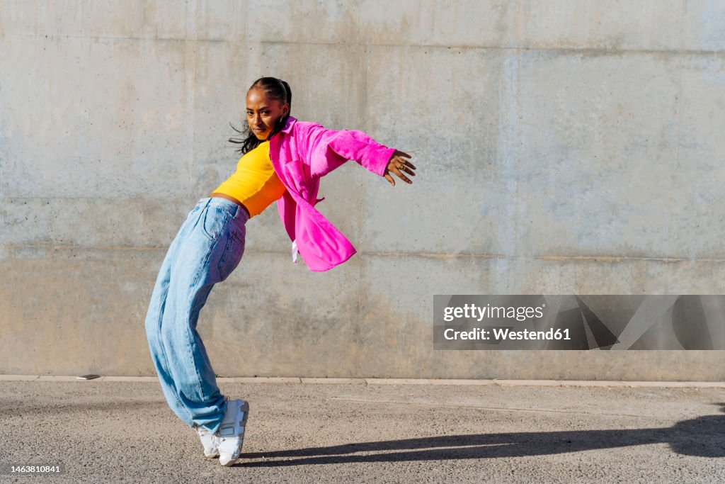 Dancer on tip toe in front of wall