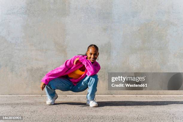happy dancer in squatting position on footpath - agachar se imagens e fotografias de stock