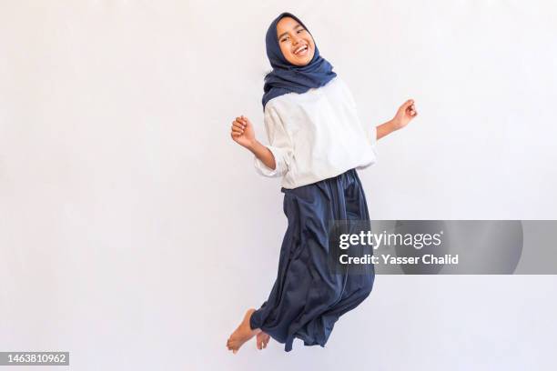 teenage girl jump - islamic action front stock pictures, royalty-free photos & images