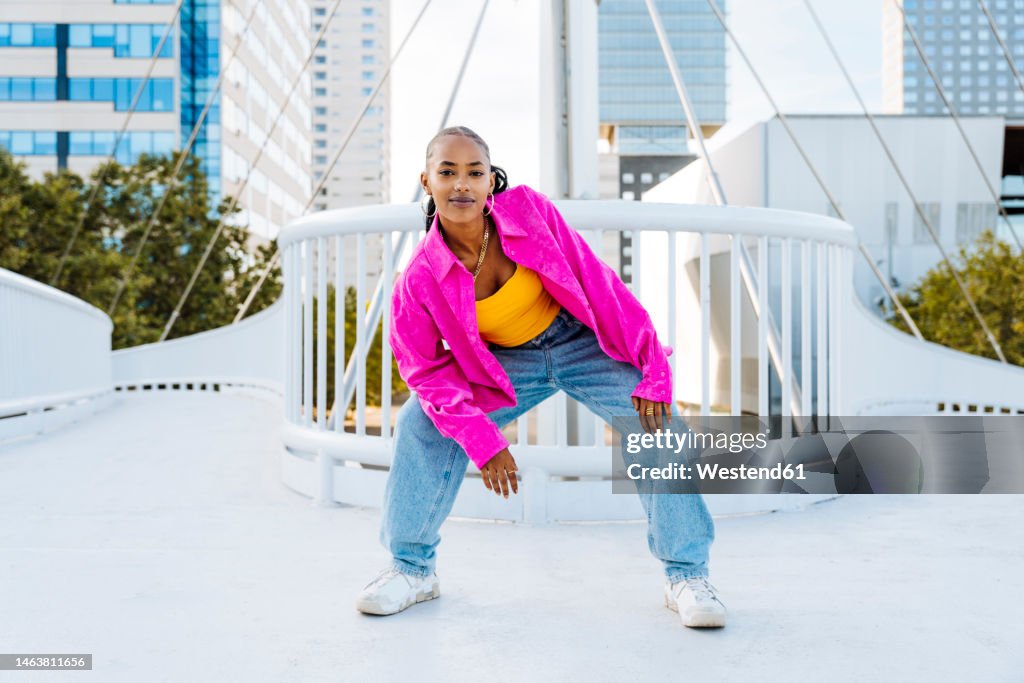 Confident young dancer breakdancing on footbridge