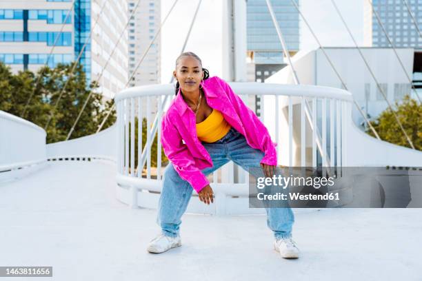 confident young dancer breakdancing on footbridge - posen stockfoto's en -beelden