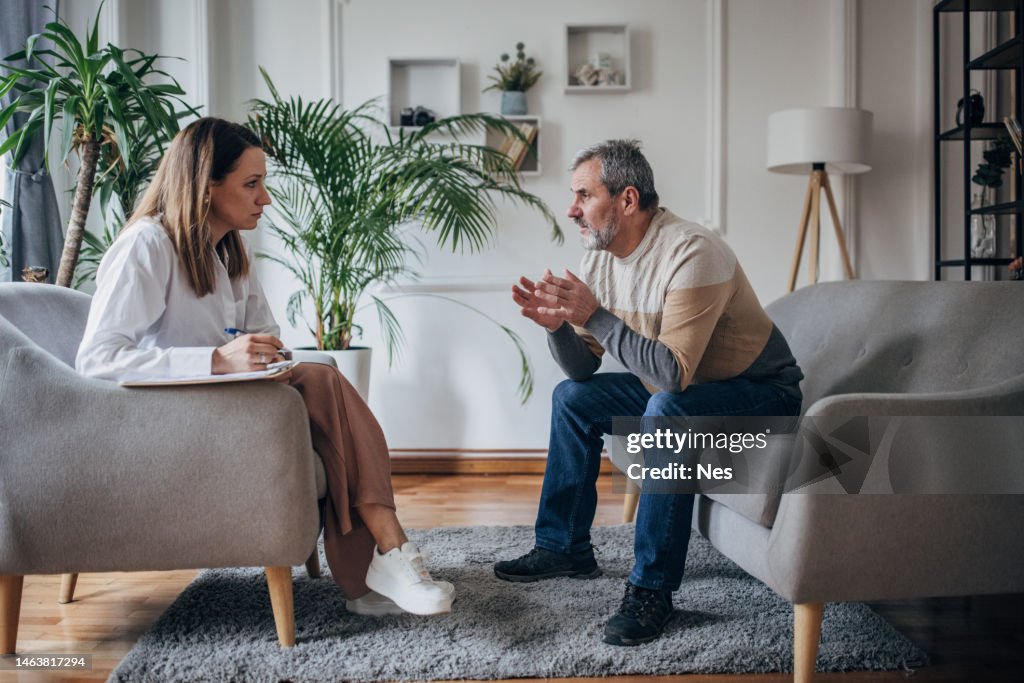 Psychotherapy, young woman doctor talking to an older man