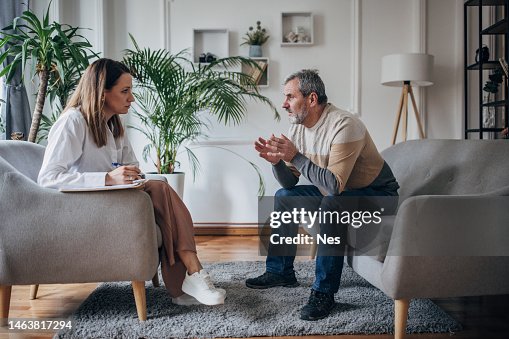 Psychotherapy, young woman doctor talking to an older man Psychotherapy, young woman doctor talking to an older man