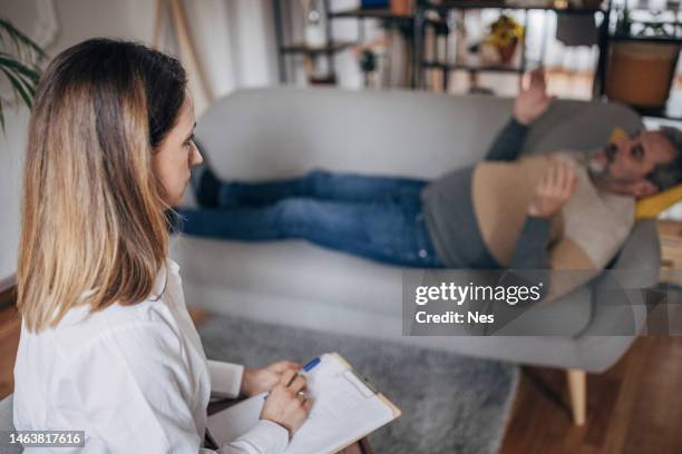 psicoterapia, médico da mulher jovem conversando com um homem mais velho - divã de psiquiatra - fotografias e filmes do acervo