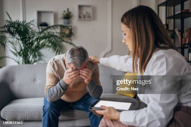 psychotherapy, young female doctor talking to elderly man, support hand - dementia test stock pictures, royalty-free photos & images