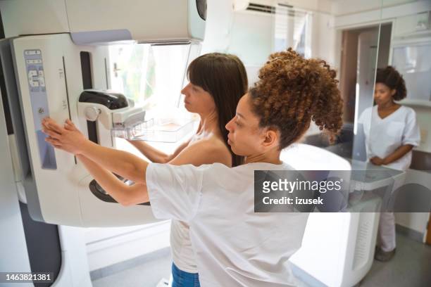 ärztin und patientin beim mammographie-test im untersuchungsraum - mammographie stock-fotos und bilder