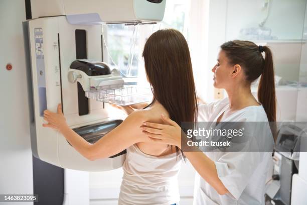 krankenschwester und patientin beim mammographie-test im untersuchungsraum - mammographie stock-fotos und bilder